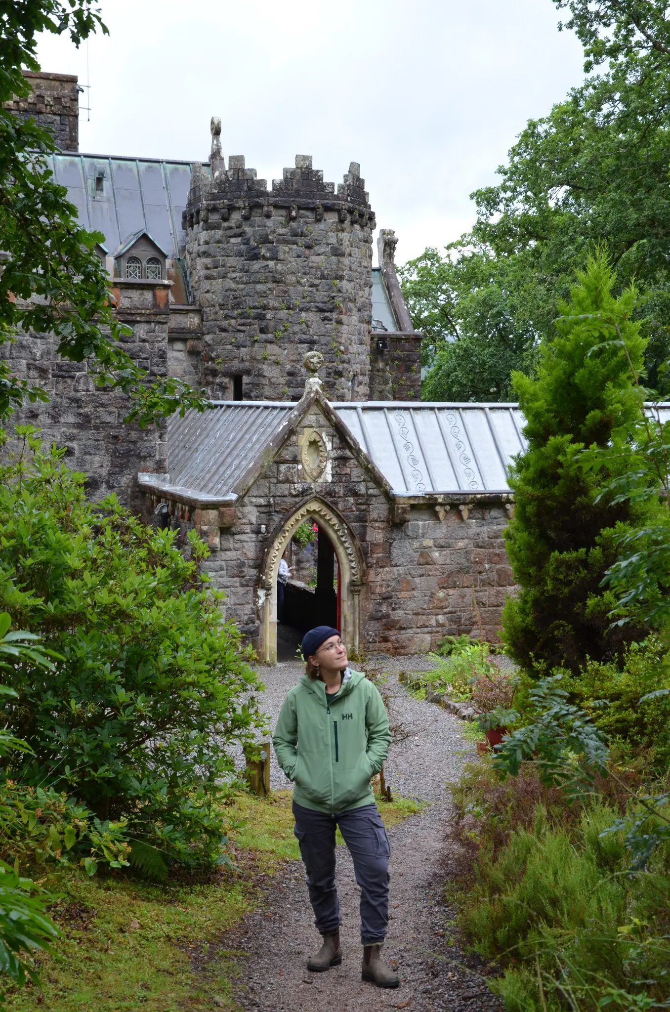 person looking up at a historic stone castle in Scotland