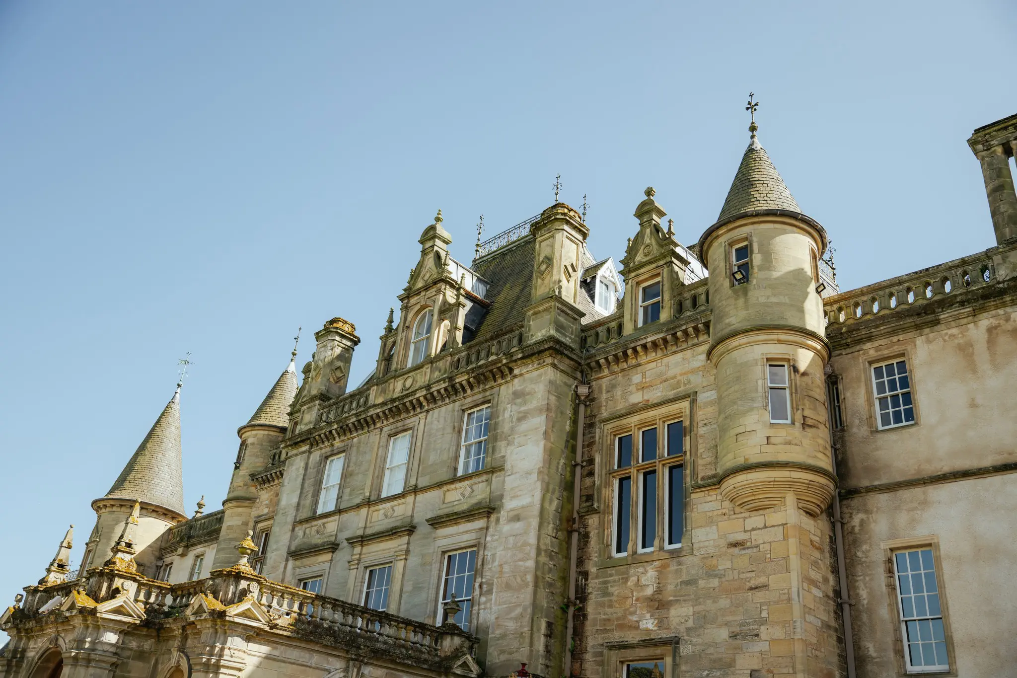 historic Scottish castle exterior with turrets and clear sky