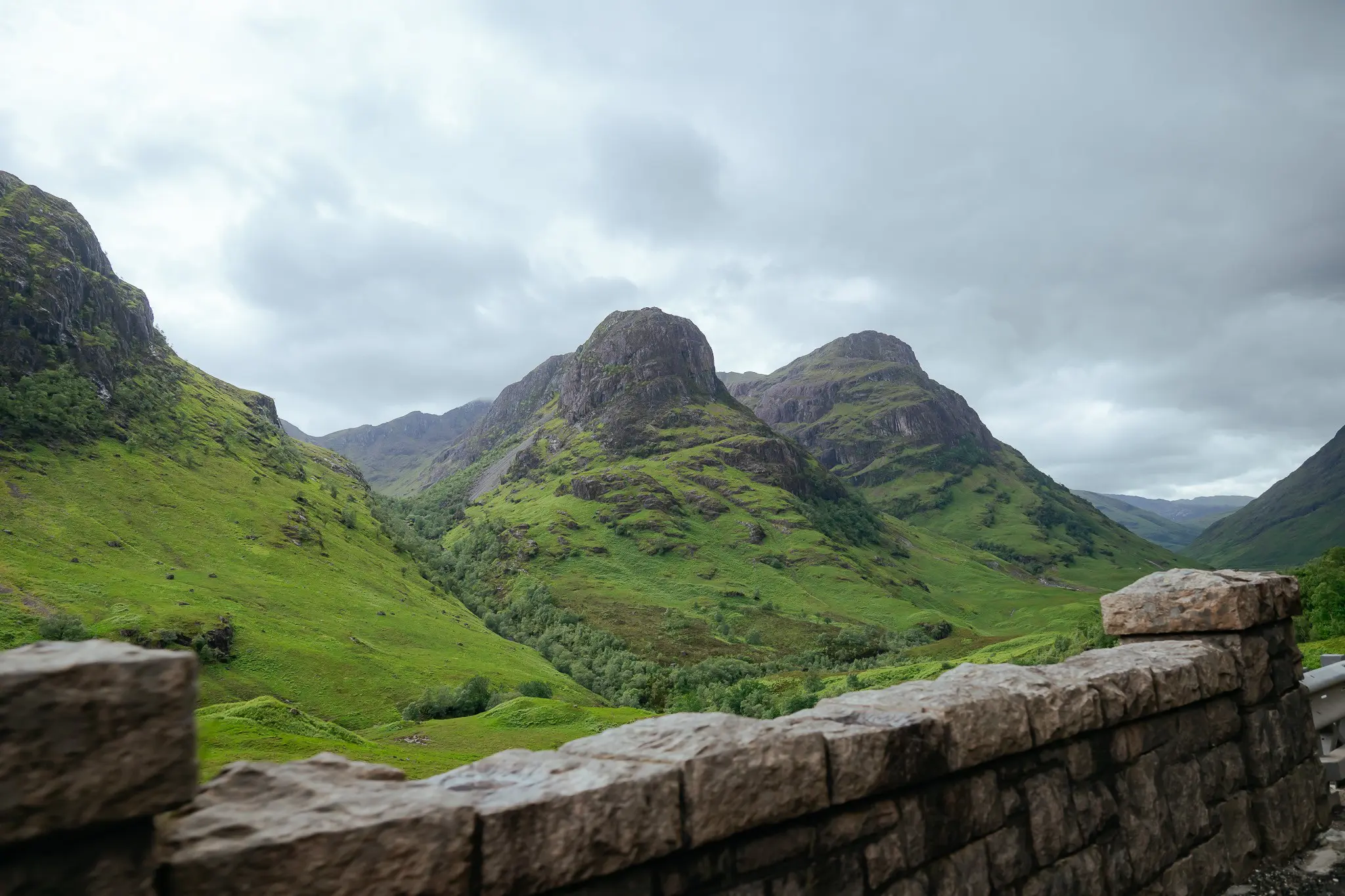 Glencoe valley in Scotland with green mountains and stone wall