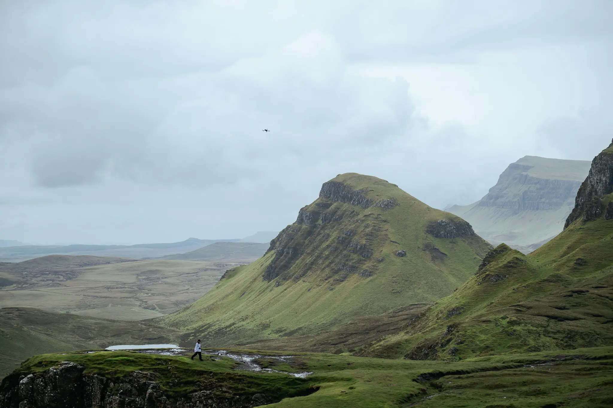 hiker walking through the Quiraing landscape in Scotland