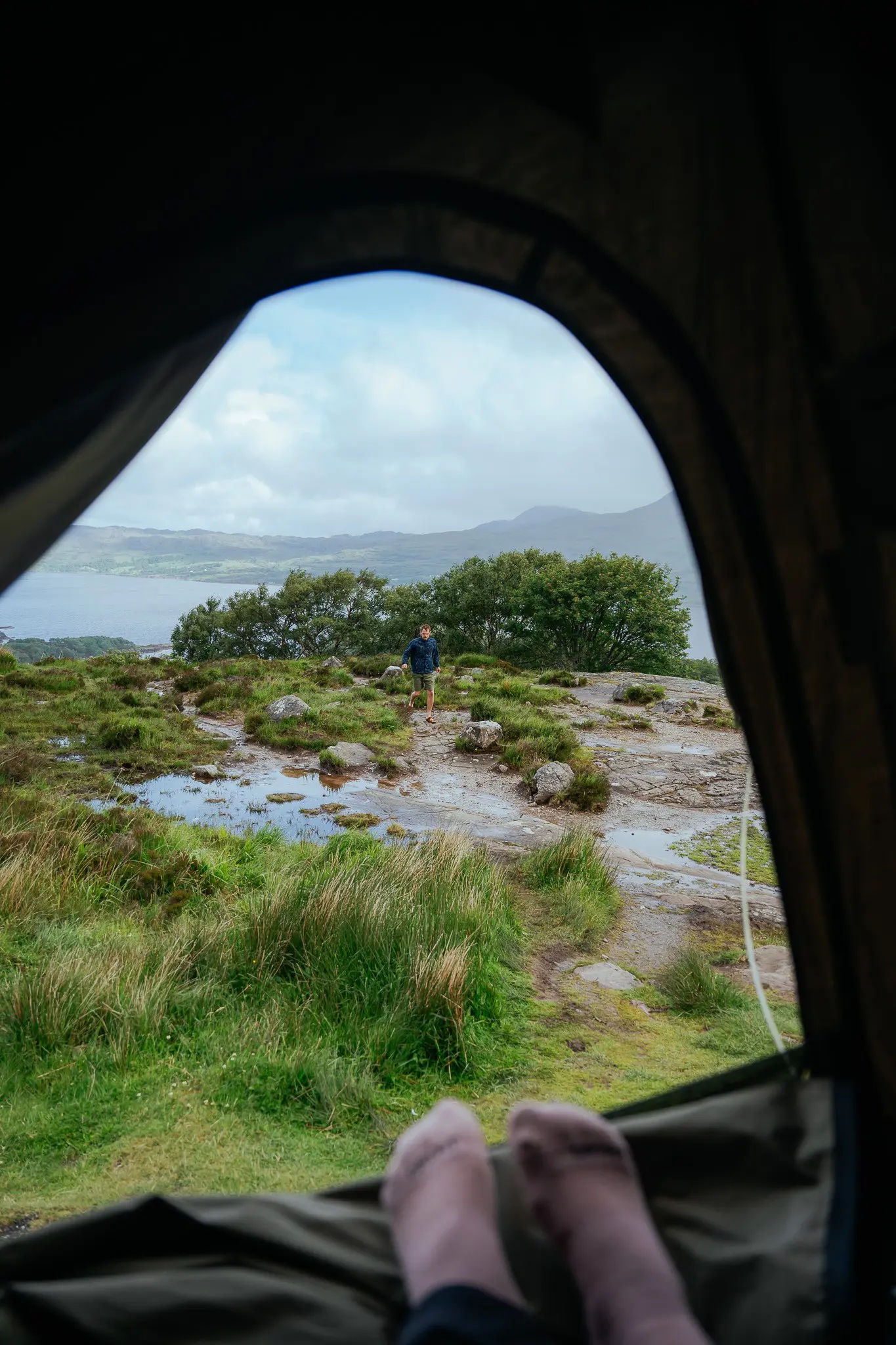 view from tent of person standing in Scottish landscape