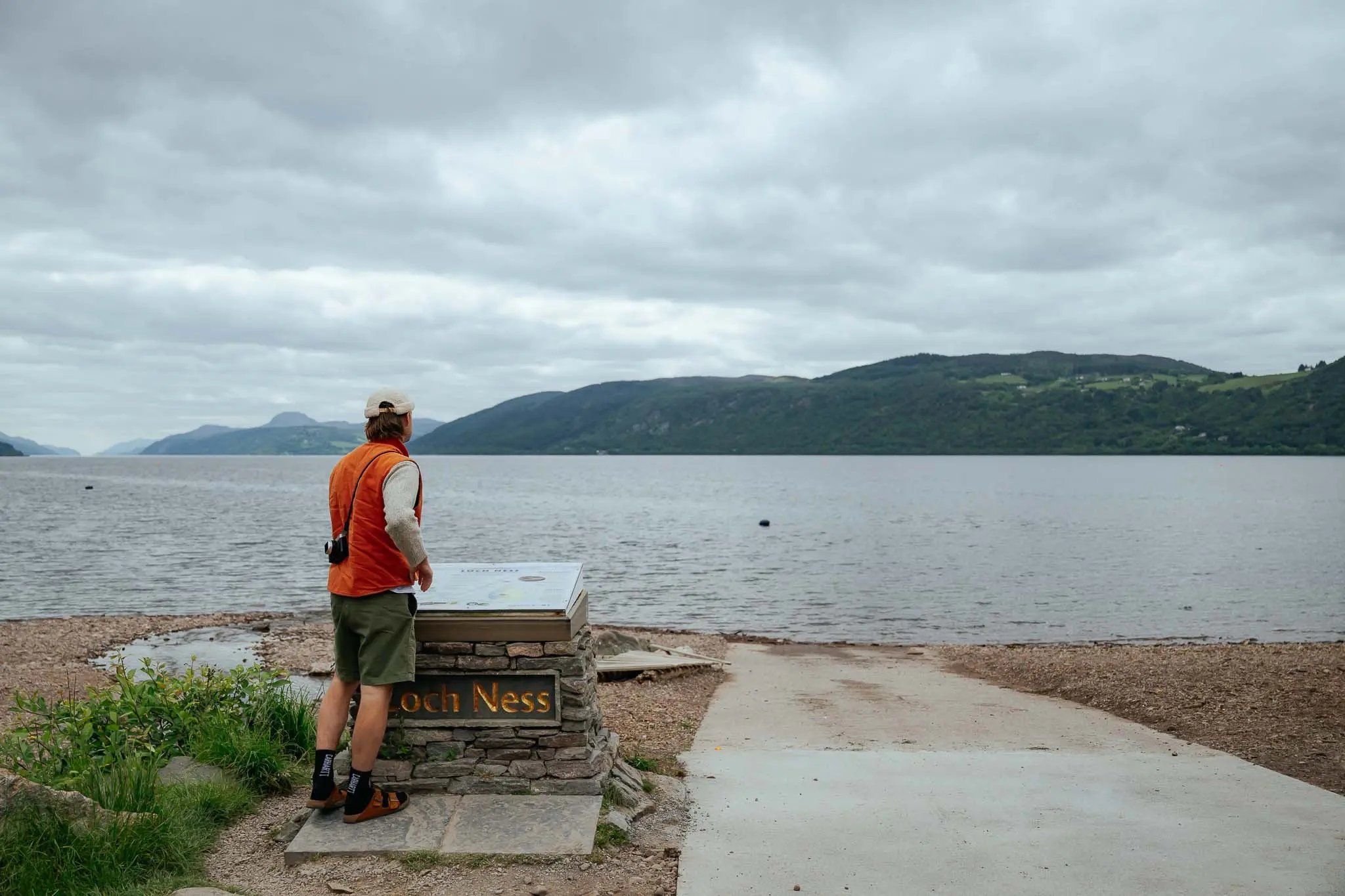man looking at Loch Ness information board in Scotland