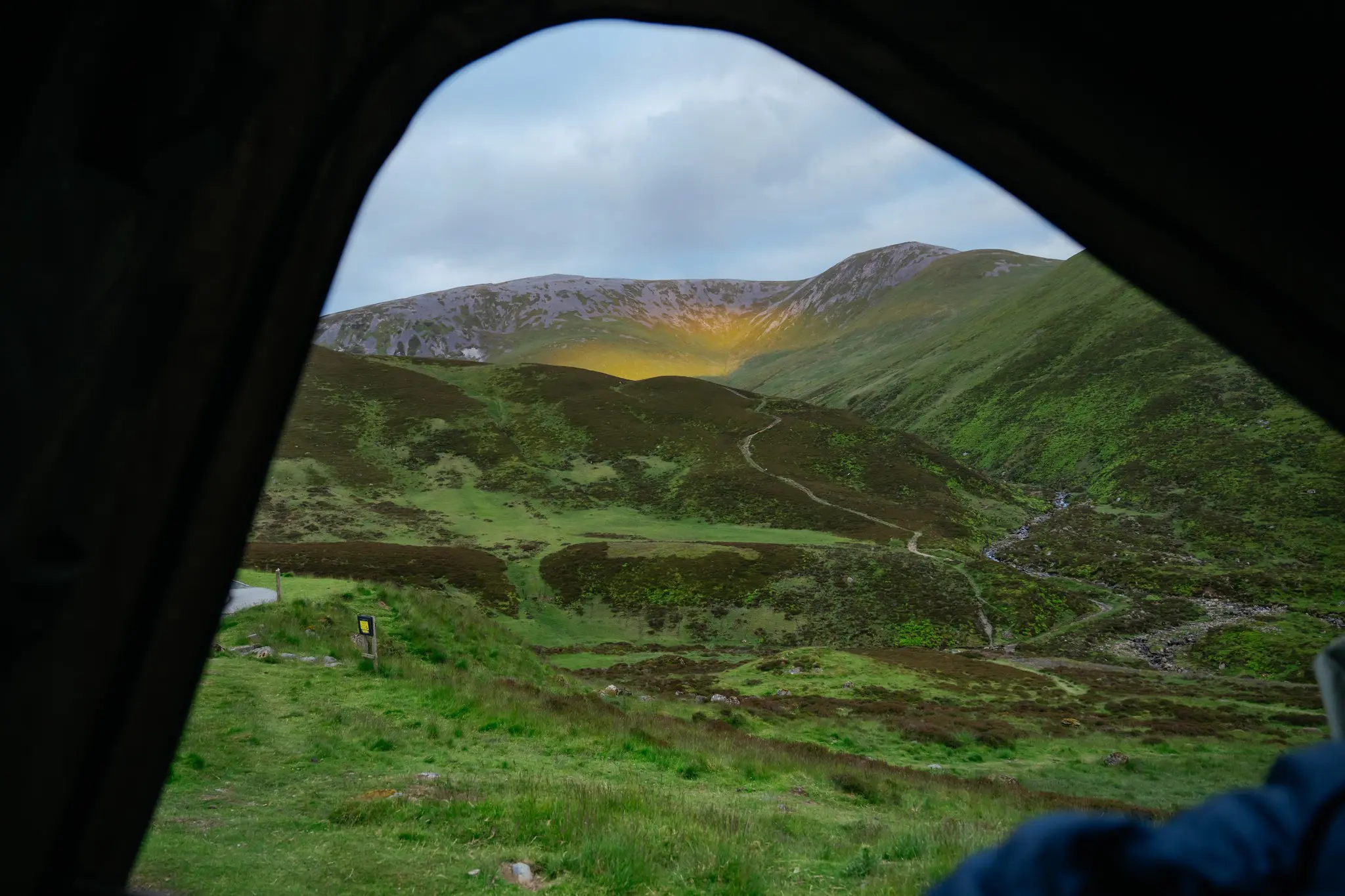 view from tent of Scottish mountains and valley at sunset