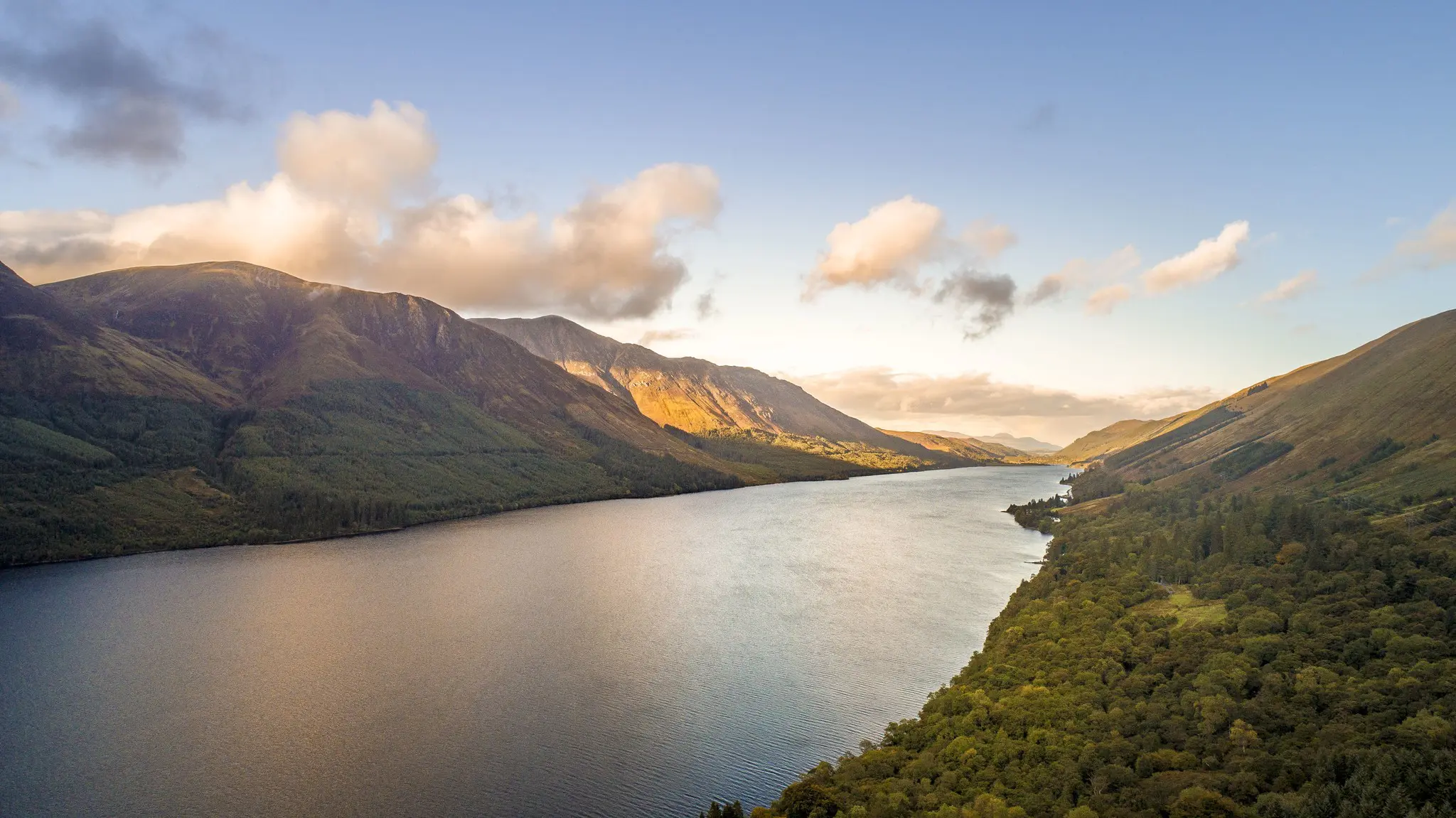 aerial view of Loch Ness lake and mountains at sunset