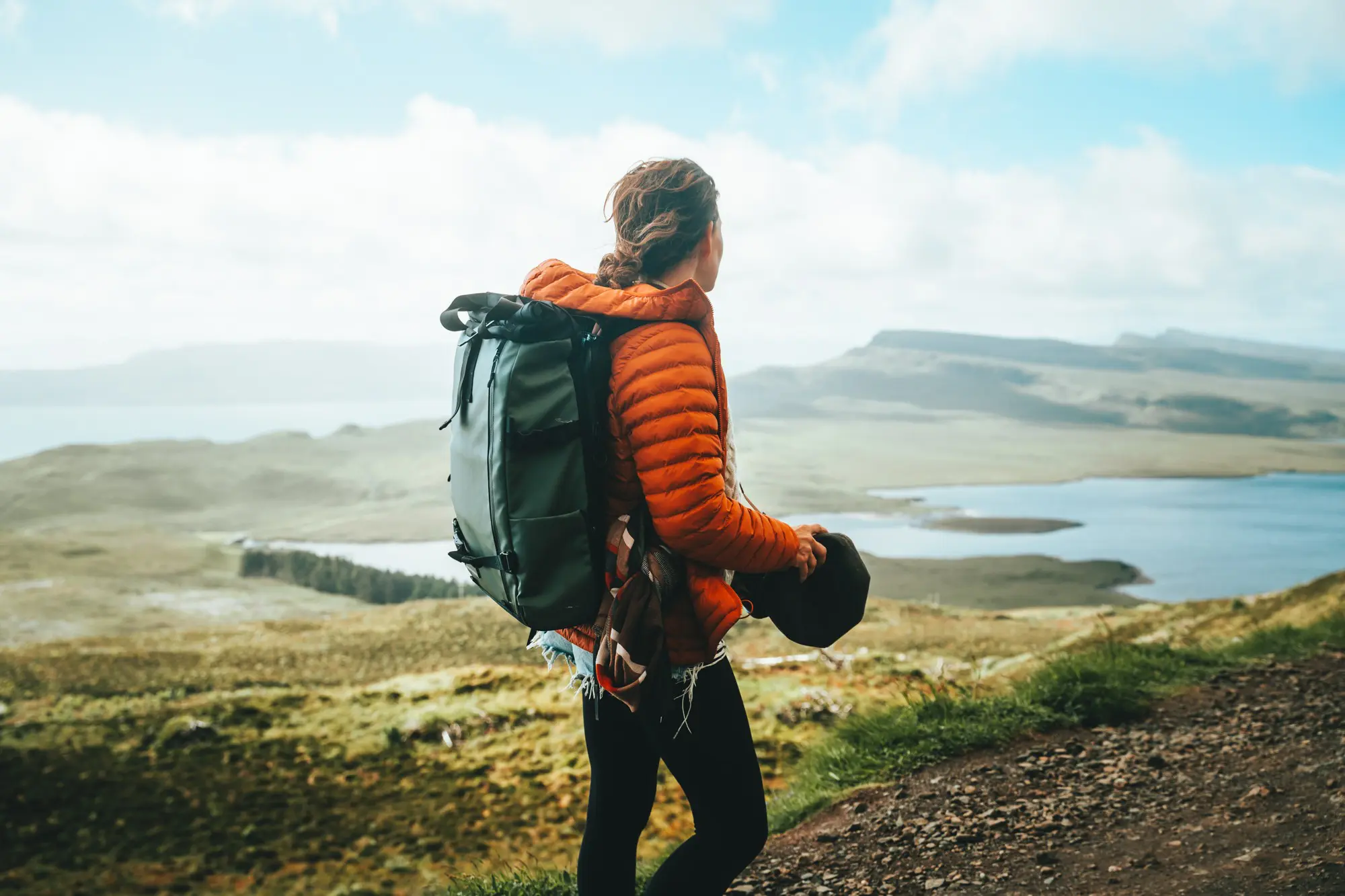 hiker with backpack overlooking a vast Scottish landscape