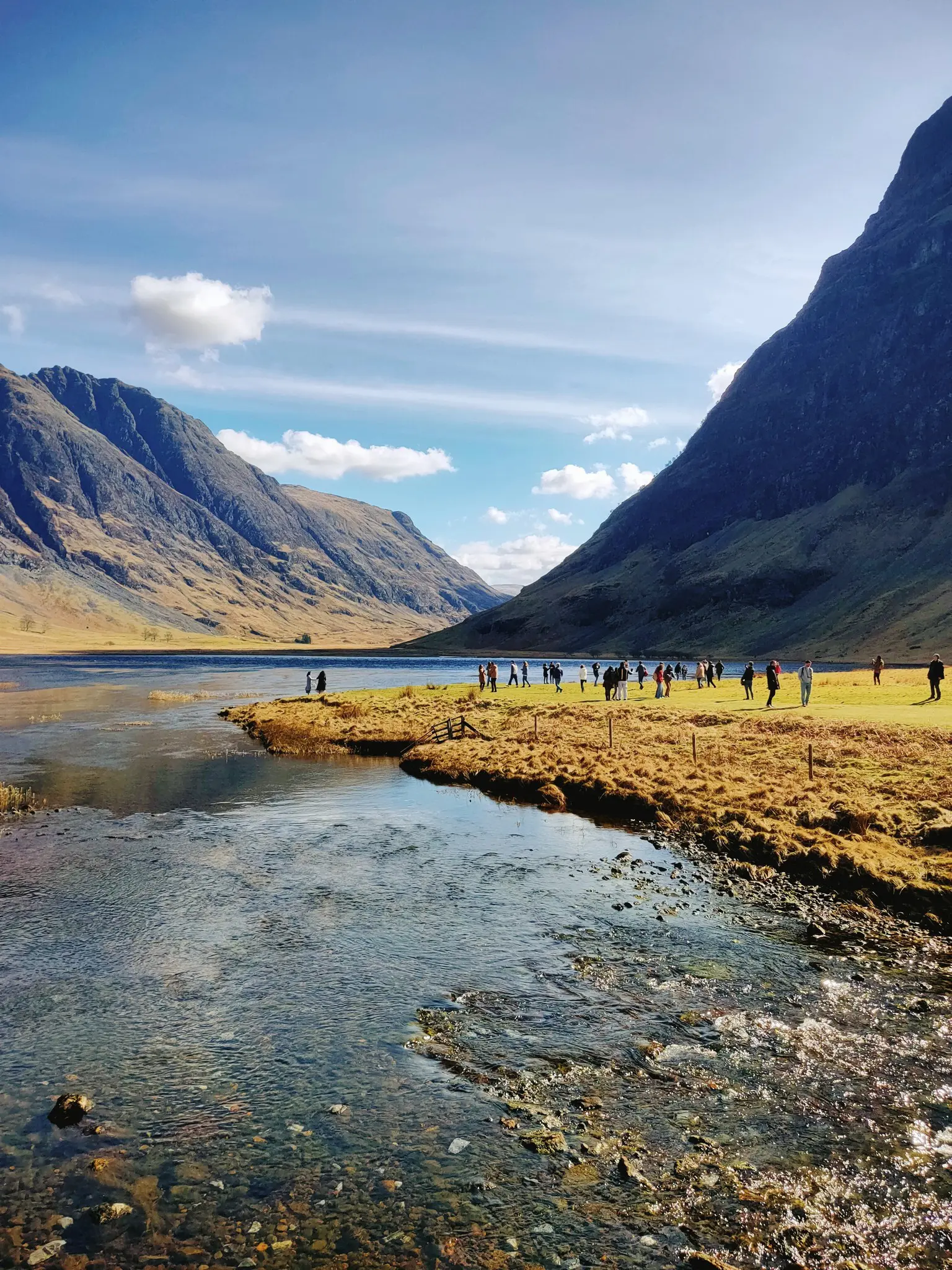 group of people by a river in a scottish valley