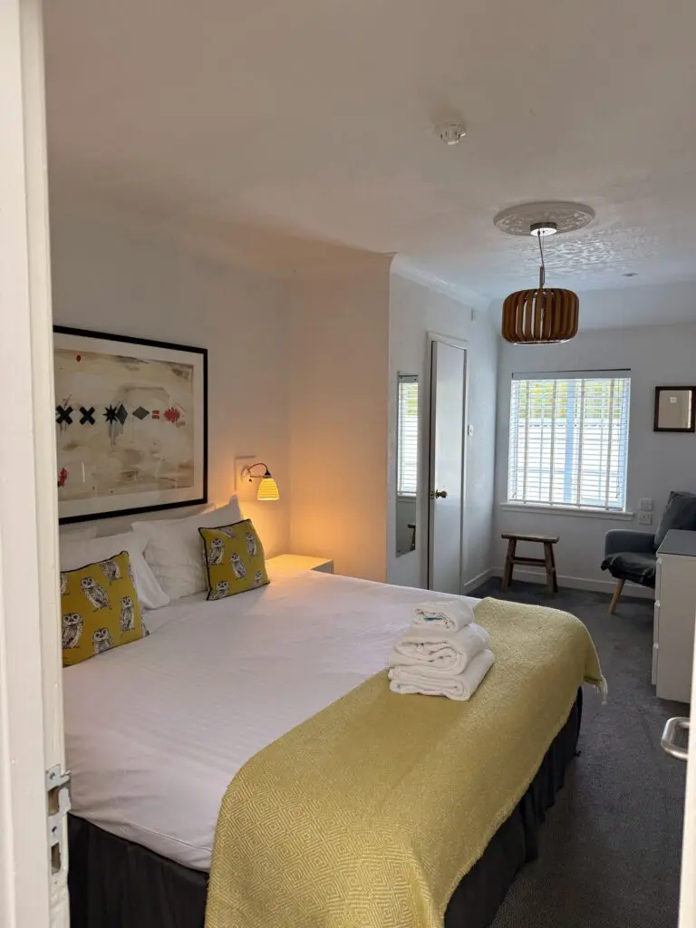 cozy hotel room with a double bed and yellow accents