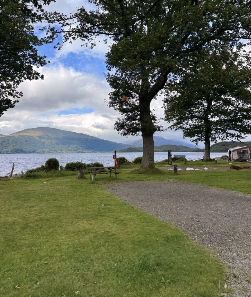 Campingplatz an einem See mit Bergen und Bäumen